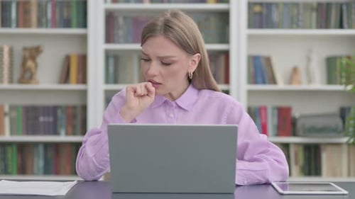 Woman Coughing with Sore Throat in Front of Laptop