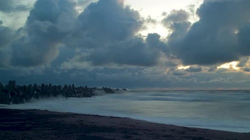 Time lapse of fasting dark dramatic storm clouds and big waves at the beach near the Northern Pier i