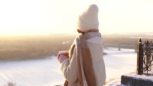 Woman Enjoying Coffee at Sunrise in Winter