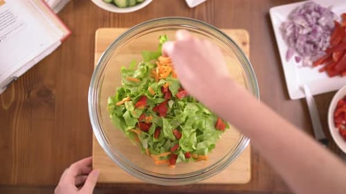 Preparing Colorful Fresh Salad in Glass Bowl