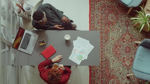 Female Colleagues Discussing Business Report in Office