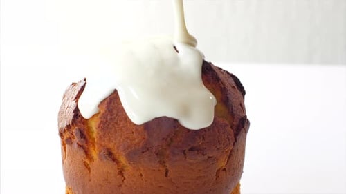 Glaze is pouring on Easter cake, close-up in slow motion