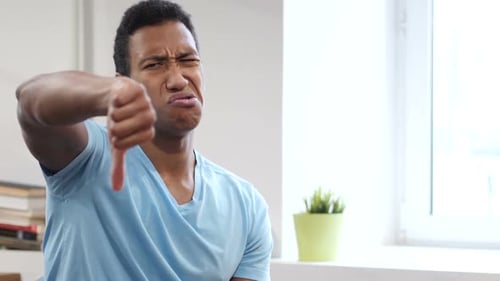 Man Gives Thumbs Down Gesture of Disapproval