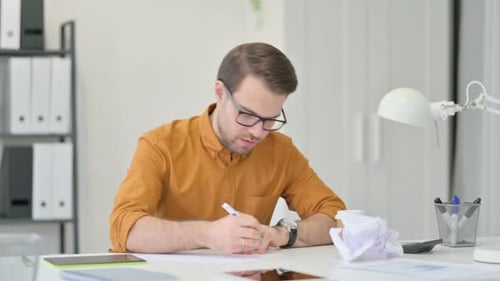 Young Adult Man Writing at Desk