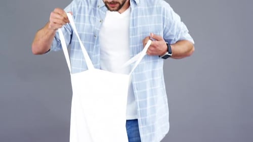 Hombre con bolso de mano sobre fondo gris