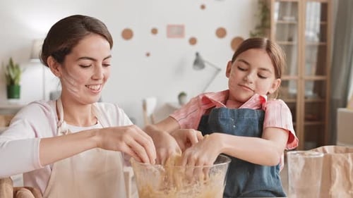 Woman and Child Mixing Dough Together Laughing