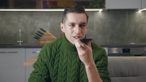 Young Adult Sending Voice Message on Smartphone Indoors