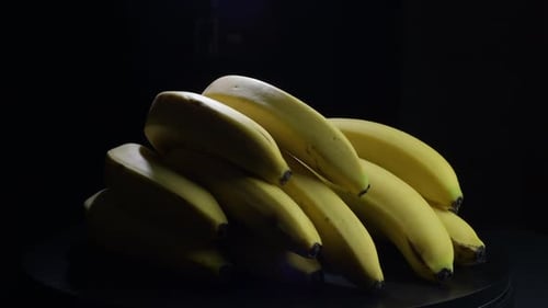 Bananas Rotating Slowly in a Dark Studio
