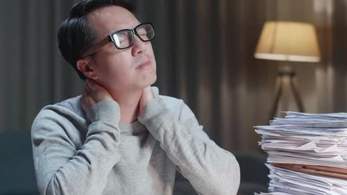 Close Up Of Asian Man Having Neck Pain While Working Hard With Documents At Home