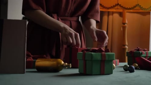 woman preparing gifts for christmas at home on the table
