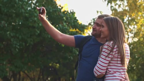 Smiling Couple Taking Selfie in a Sunny Park