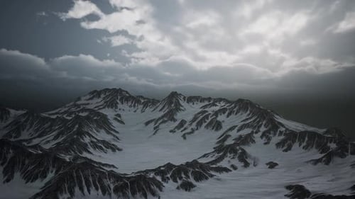 Aerial View of Snowy Mountain Range with Dramatic Moving Clouds