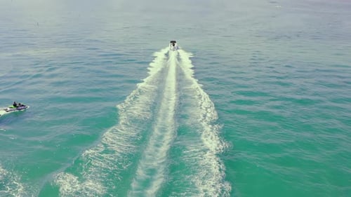 Speed Motor Boat Sailing on Blue Sea Water Leaving White Swirl Trails Behind at Summer
