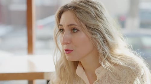 Closeup Portrait of Young Confident Caucasian Blond Woman Talking and Eating in Restaurant on Sunny