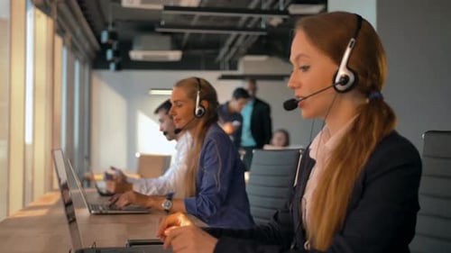 Young Friendly Operator Woman Agent with Headsets Working in a Call Centre.