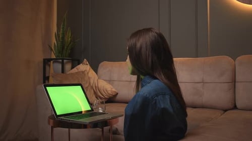 Mujer mirando en una computadora portátil con pantalla verde Chromakey viendo contenido, estudiando o trabajando en la oficina en casa