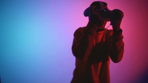 Man Plays Virtual Reality Game in Colorful Lighting