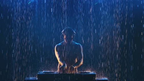 Sexy Male Dj in Professional Headphones Plays on the Control Panel for Mixing Music in a Dark Studio