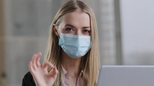 Woman Wearing Mask Gives OK Sign at Work