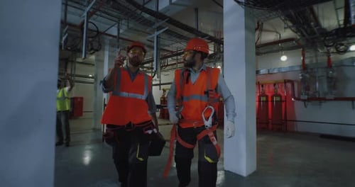 Trabajadores varones caminando y hablando en la fábrica