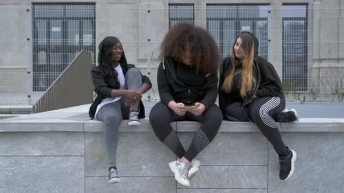 Three Friends Chatting Together in an Urban Setting