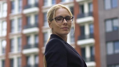 Confident Woman in Blazer Standing Near City Building