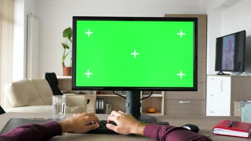 First Person View - Man Hands Typing on Computer Keyboard with Big Green Screen Chroma Mock-up