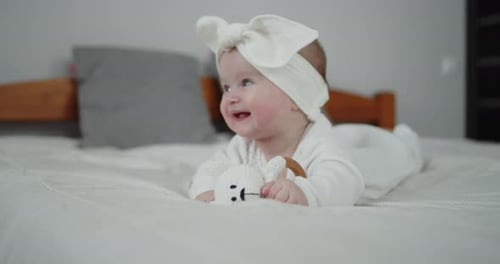 Adorable Baby Smiling Lying on White Bed