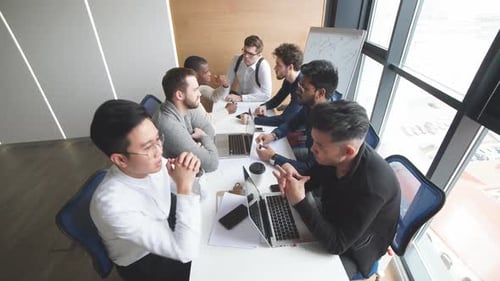 Multiethnic Male Team Analyzing Data While Sitting at the Desk in Office.