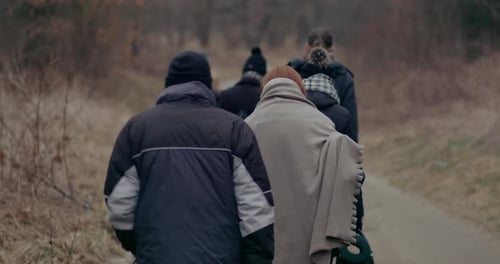 War Refugees With Luggage Walking On Road