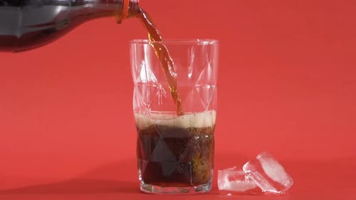 Refreshing Soda Being Poured into Glass with Ice