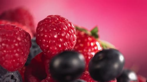 Fresh Berries Falling Macro Shot on Pink Background