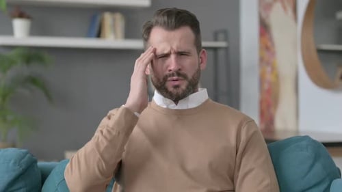 Man Rubbing Temples Experiencing Headache