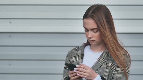 Woman Using Smartphone Outdoors, Urban Background
