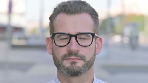 Close Up of Young Adult Man Face Looking at the Camera Outdoor