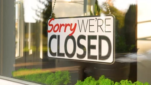 Sorry We're Closed Sign Hanging in Window