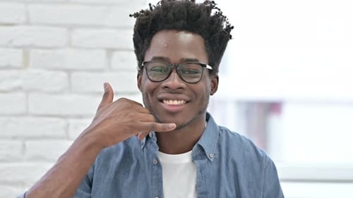 Young African Man Asking for Call with Hand Sign