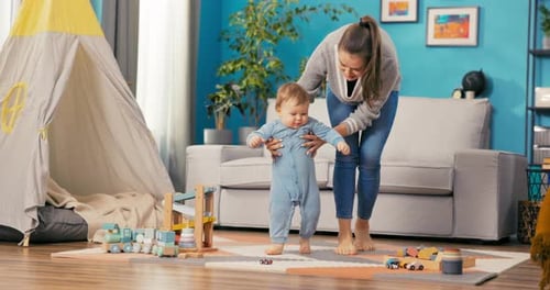 Mother Helping Baby Take First Steps at Home