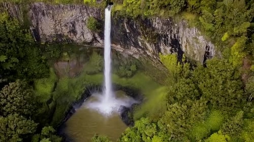 Aerial View of Waterfall Surrounded by Lush Greenery