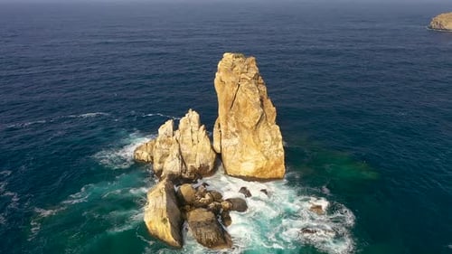 Des milliers d'oiseaux survolent une petite île vue aérienne