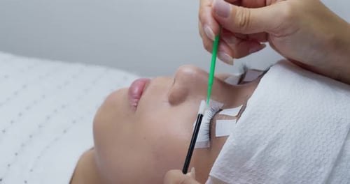 Mulher jovem e bonita com extensão de cílios no salão