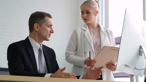 Two Business People Talk Project Strategy at Office