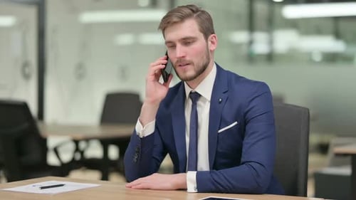 Young Adult Talking on Cell Phone in Office
