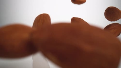 Mandeln fallen auf die Oberfläche. Zeitlupe.