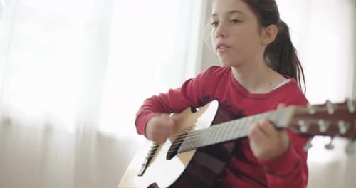 Girl Plays Guitar and Sings Inside Home