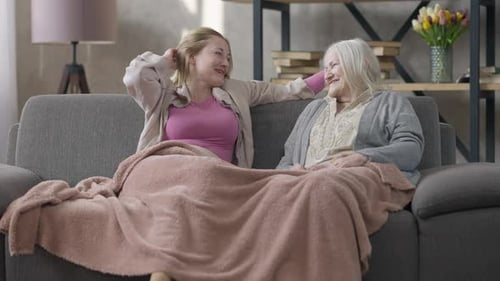 Two Women Chatting on the Couch at Home