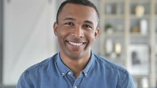 Porträt eines lächelnden jungen afrikanischen Mannes mit Blick in die Kamera