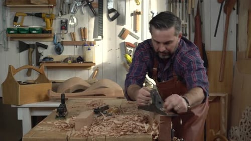 Cabinetmaker Planes Solid Wood in his Workshop
