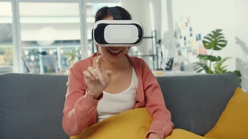 Woman Enjoys VR Headset Experience on Sofa