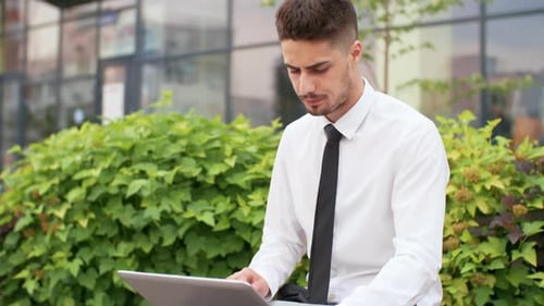 Young Adult Working on Laptop Outdoors